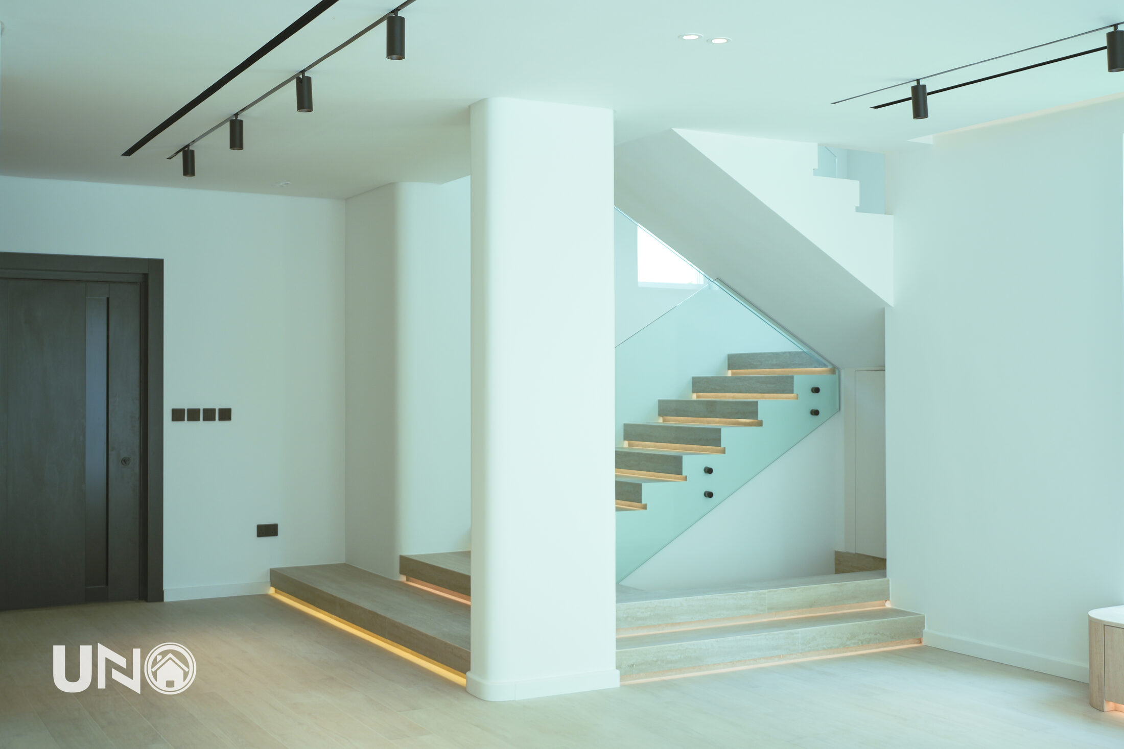 Floating oak-and-stone staircase in a UNO Home villa