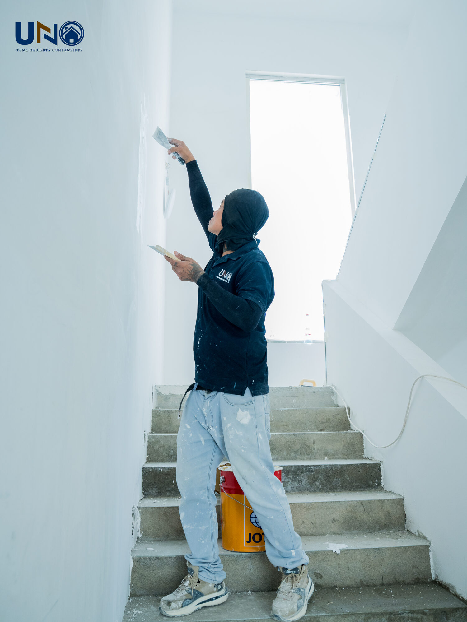 UNO Home team member finishing a staircase wall on site