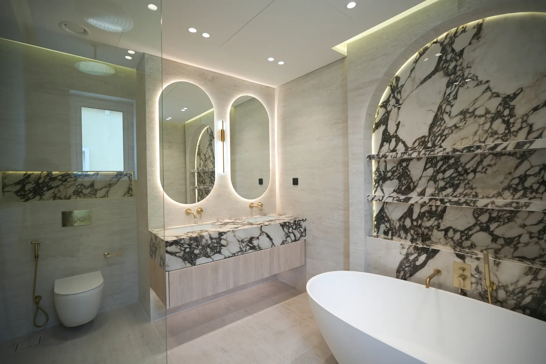Master bathroom with twin backlit mirrors, a viola marble feature wall and a freestanding tub