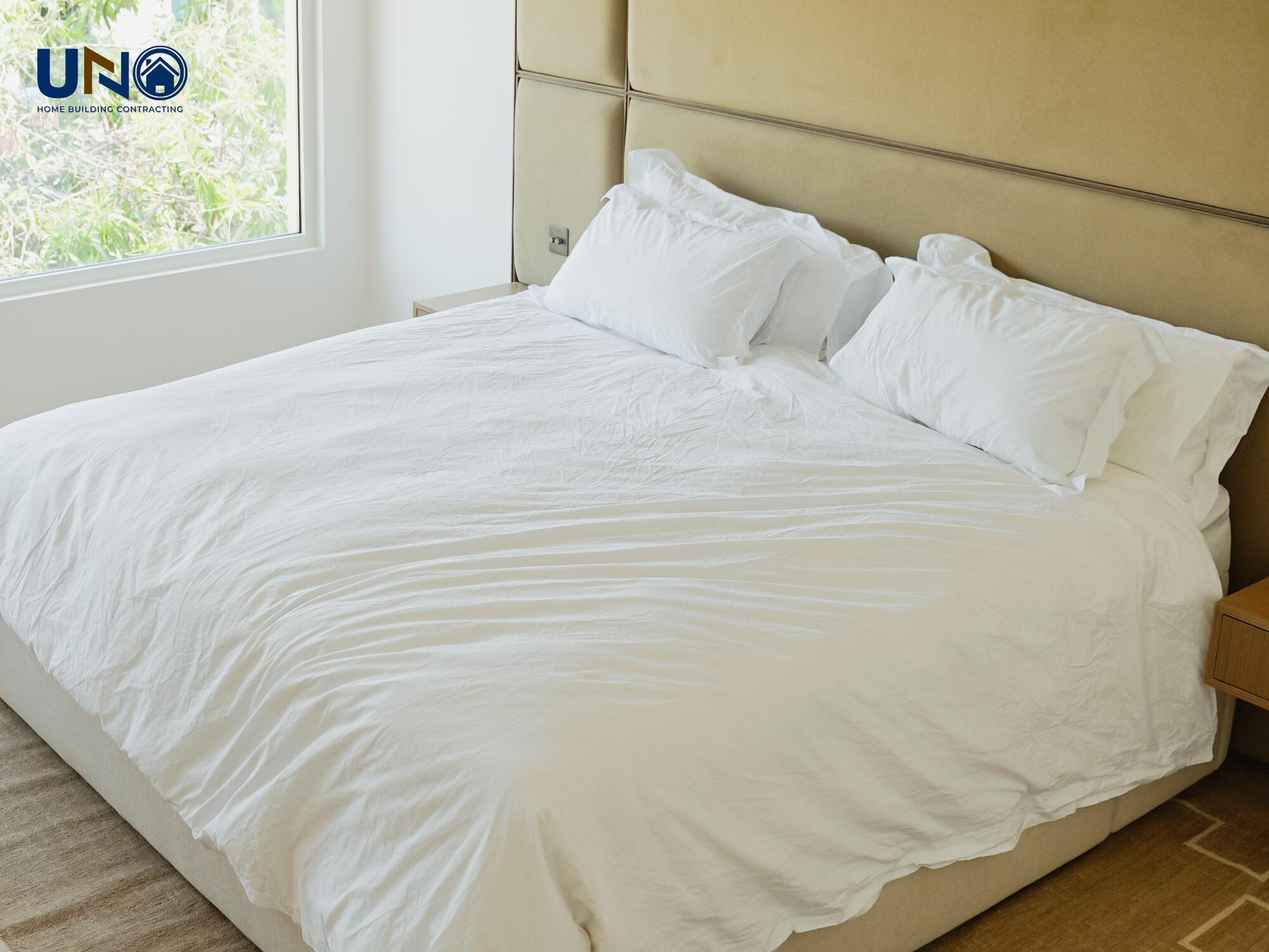 Bedroom with an upholstered headboard and soft neutral bedding