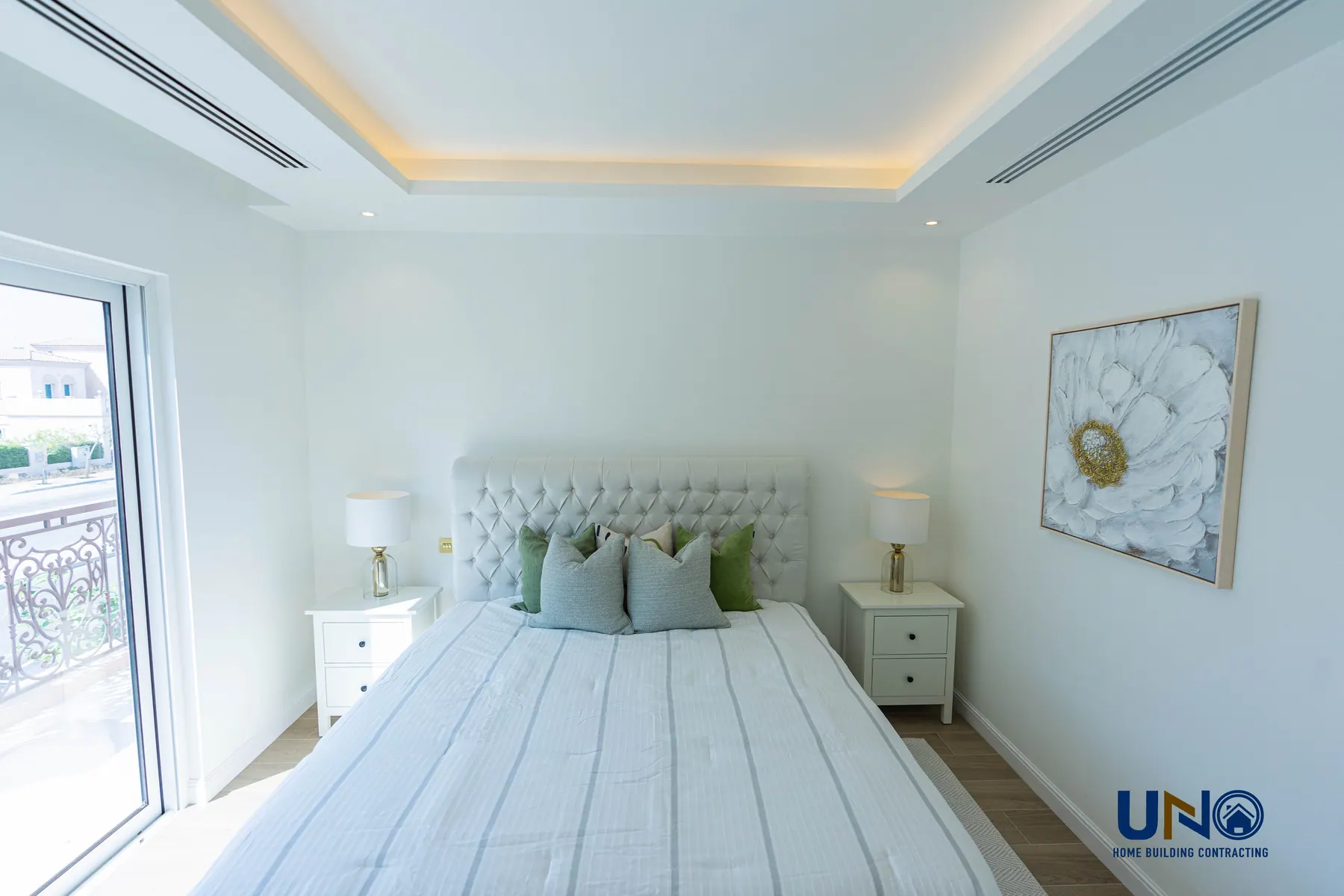 Principal bedroom with an upholstered headboard and balcony access