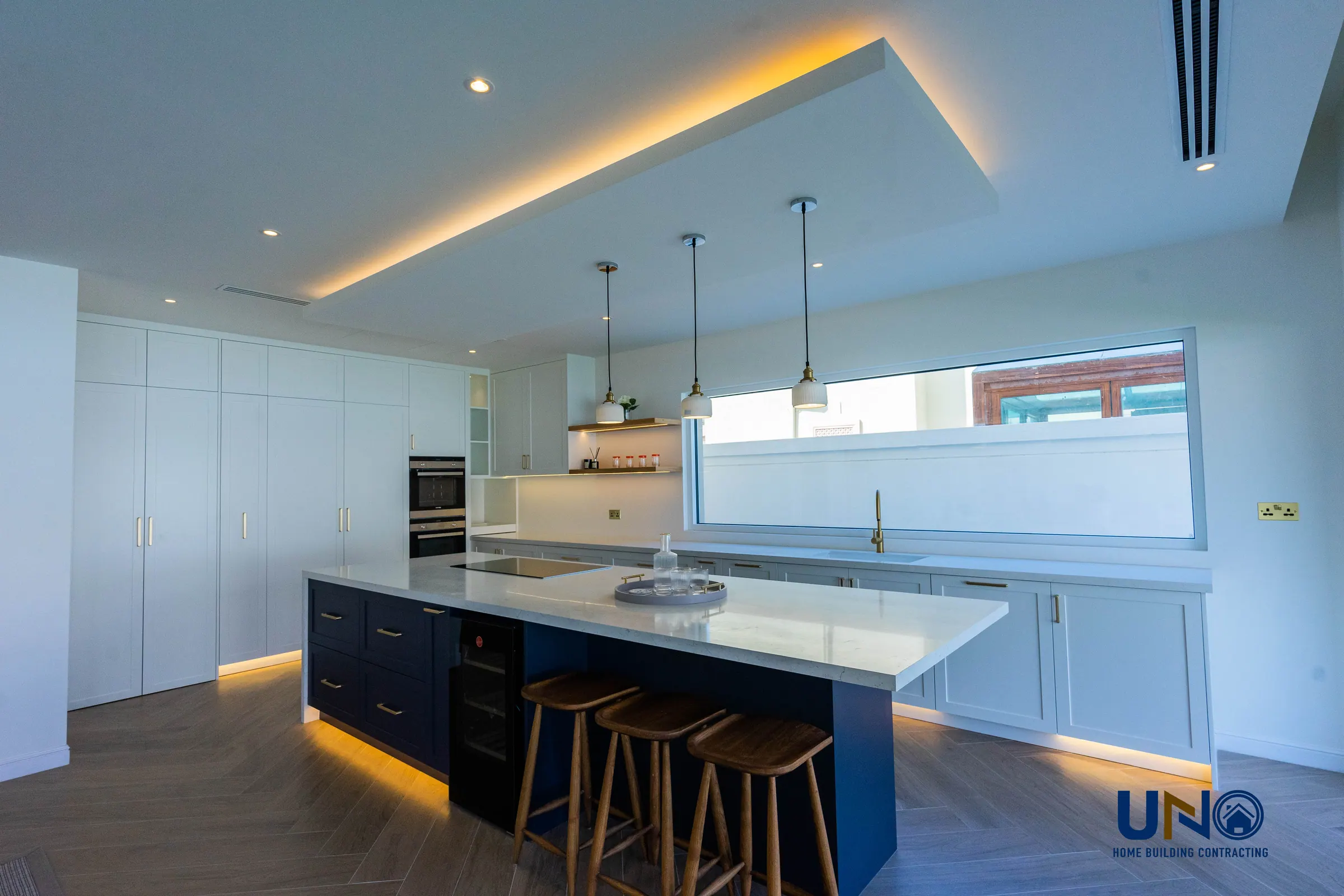 Jumeirah Village Triangle kitchen with a navy island and stone worktops