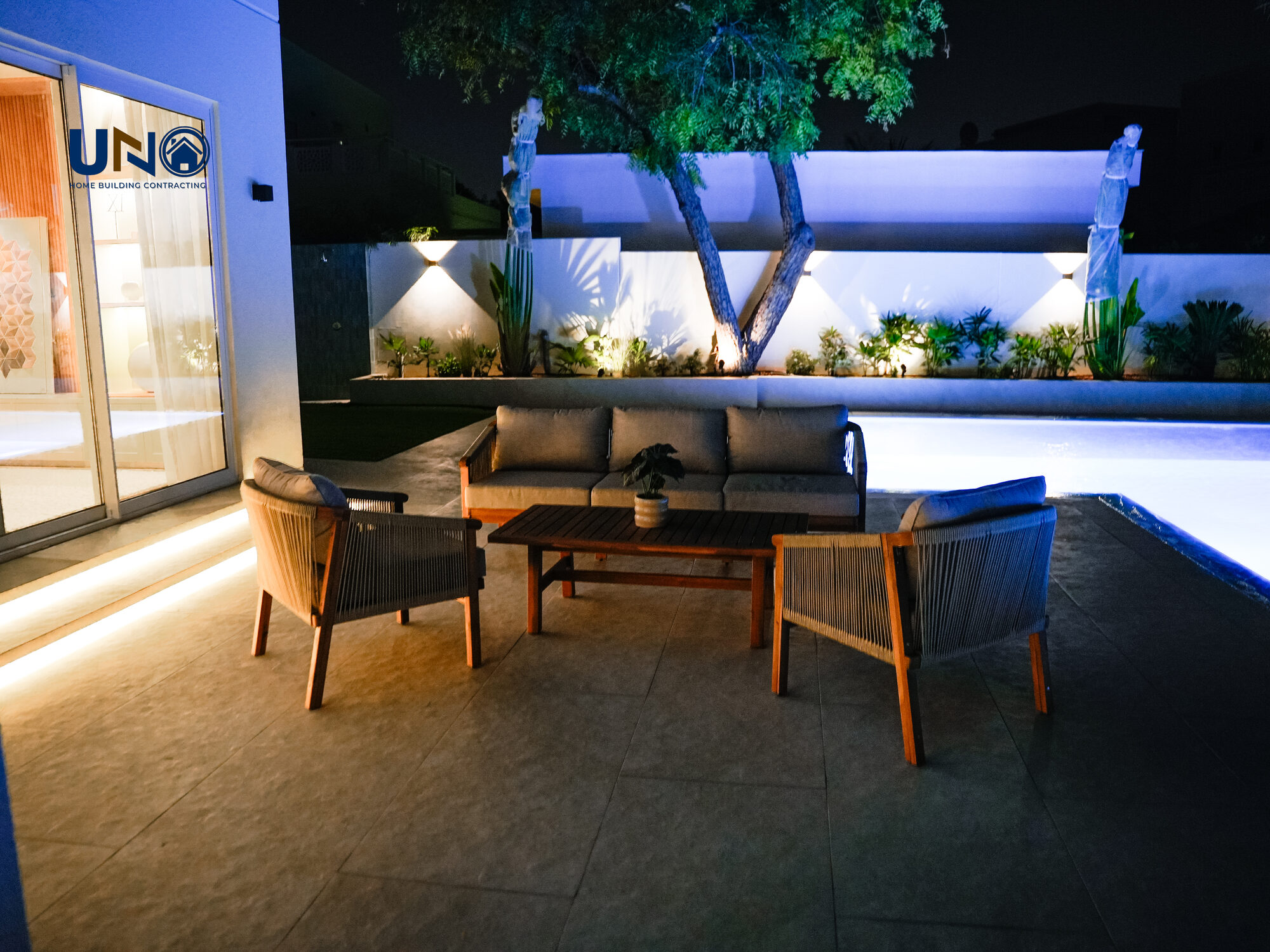 Outdoor lounge seating beside the pool at night
