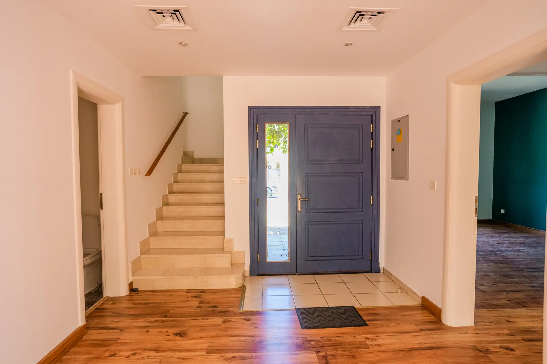 Entrance hall and staircase before renovation with dark timber and tiled floor
