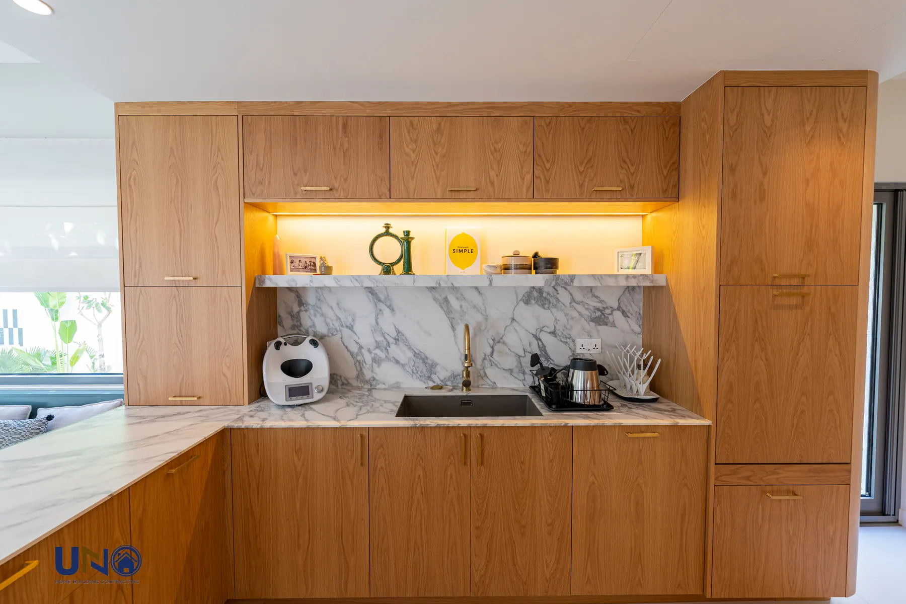New kitchen in warm oak with stone worktops and integrated appliances