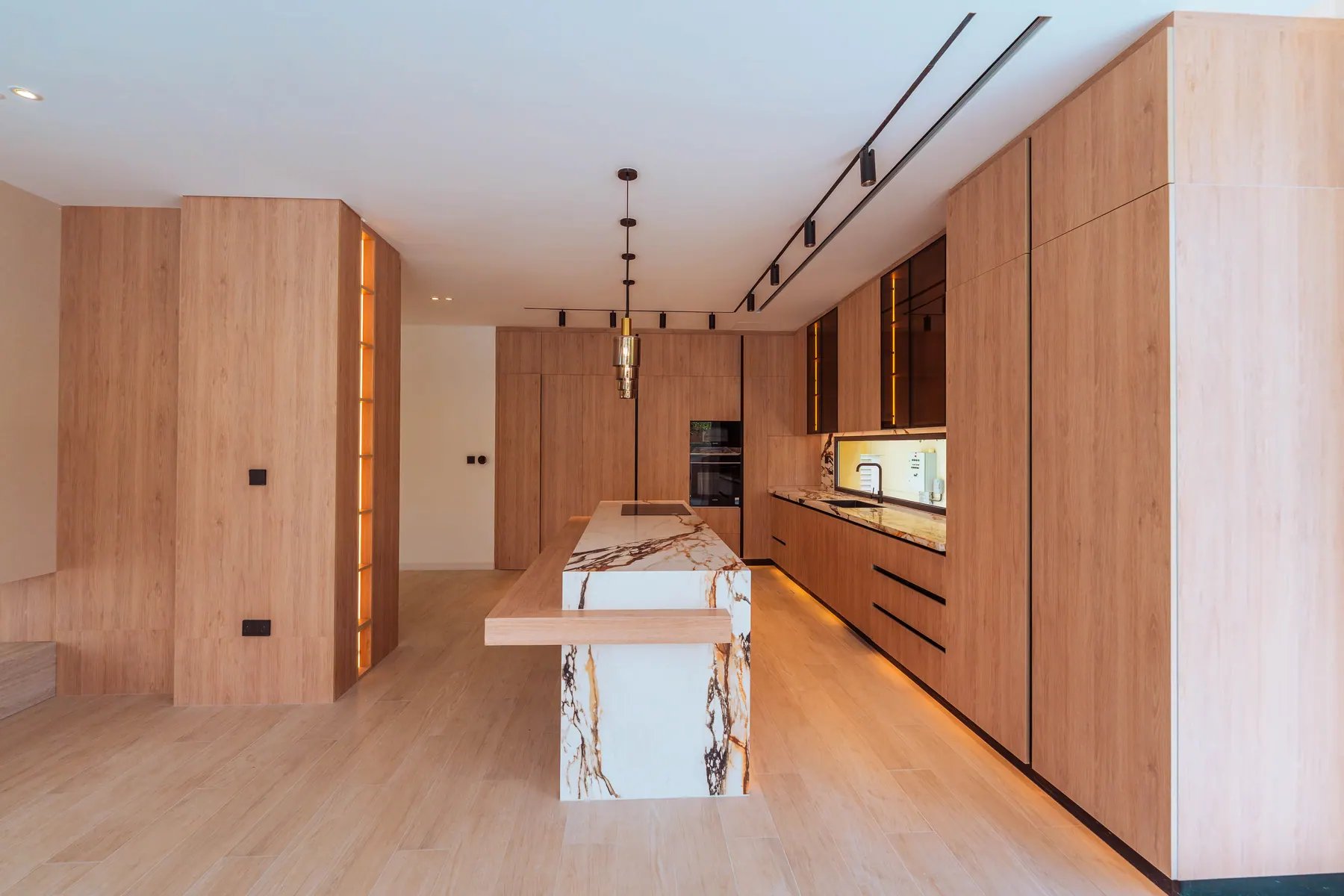Kitchen in warm oak with a viola marble island