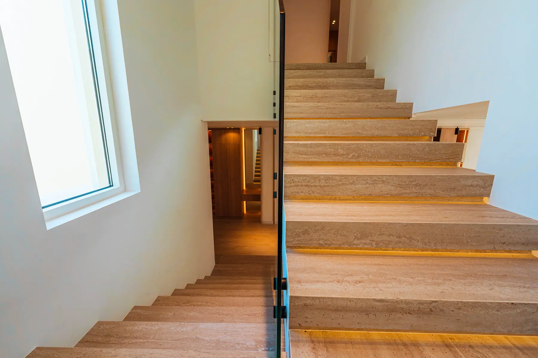 Travertine staircase with a concealed handrail