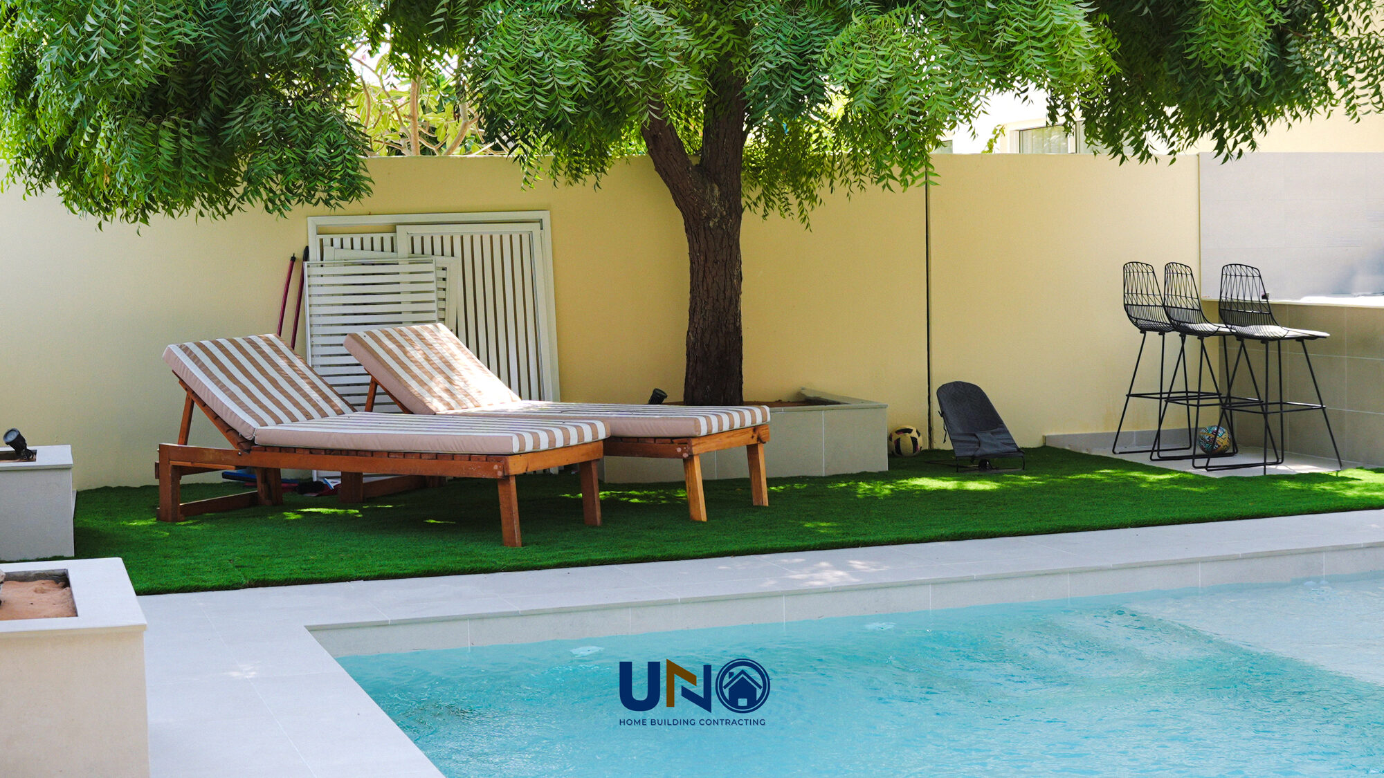 Sun loungers on turf beside the pool